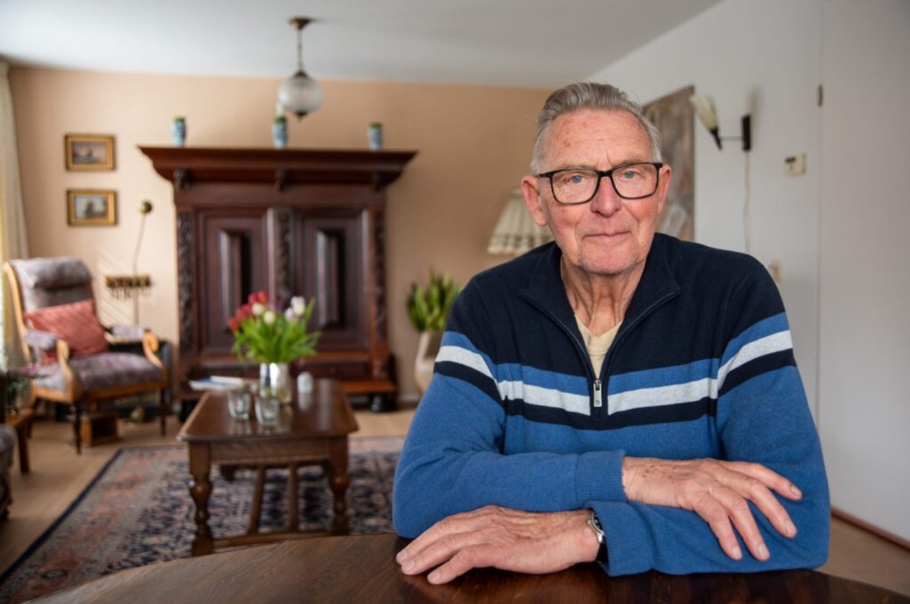 Gerrit Lubberts aan tafel in zijn woonkamer